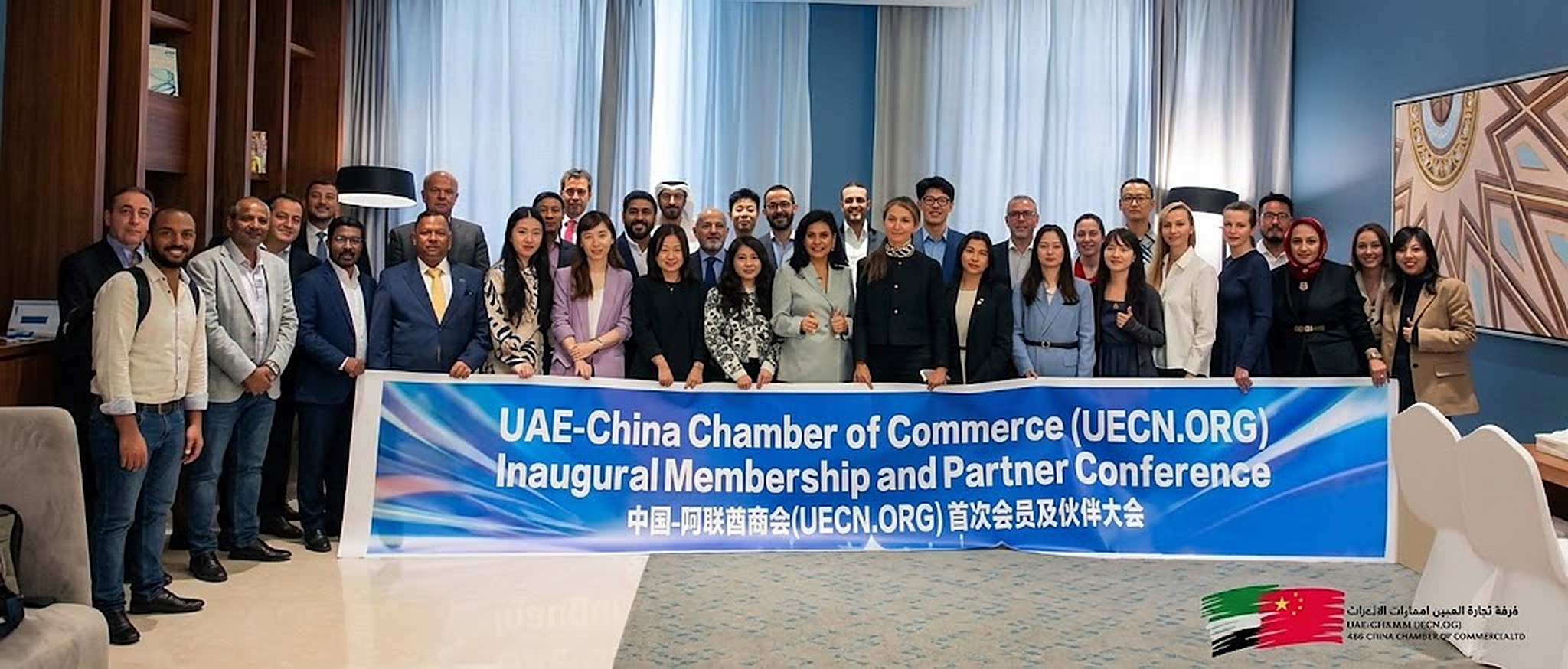 An Asian businessman and an Emirati professional shaking hands at a chamber of commerce networking event