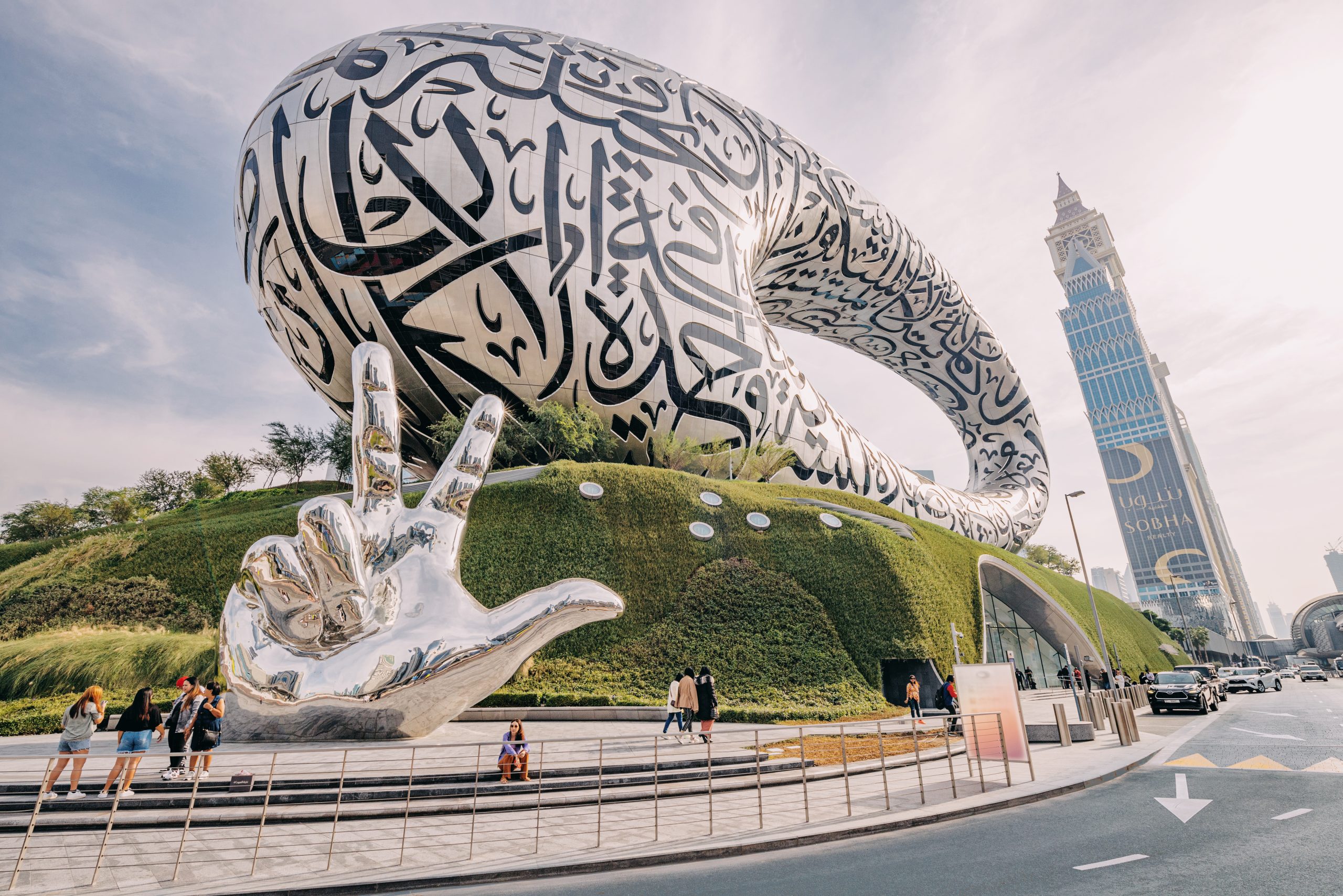 Museum of the Future in Dubai with chrome hand sculpture and skyscraper in the background