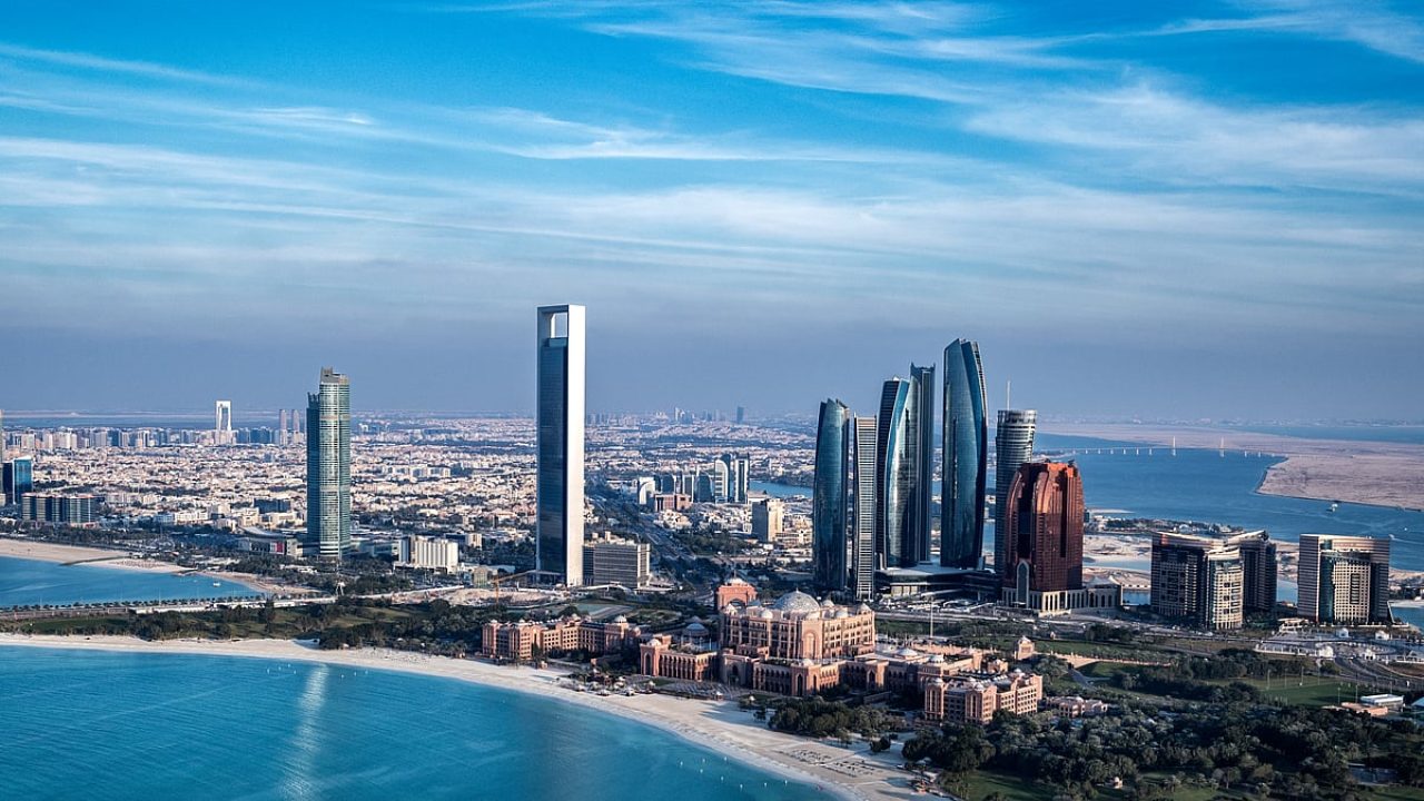 Aerial view of Abu Dhabi city skyline, beachfront, and modern skyscrapers along the Persian Gulf coast