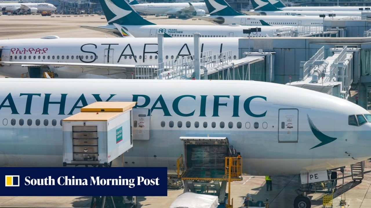 Cathay Pacific airplanes parked at boarding gates at an airport