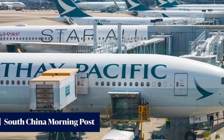 Cathay Pacific airplanes parked at boarding gates at an airport