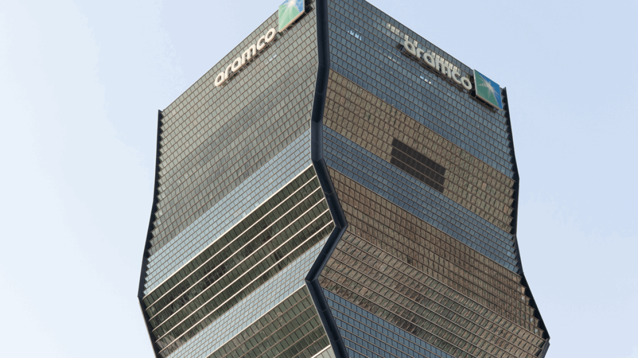 Upper facade and architecture of the Aramco skyscraper against a clear sky