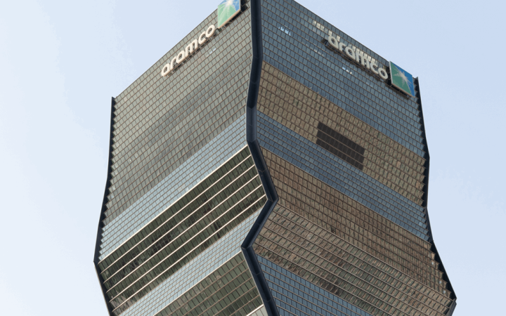 Upper facade and architecture of the Aramco skyscraper against a clear sky