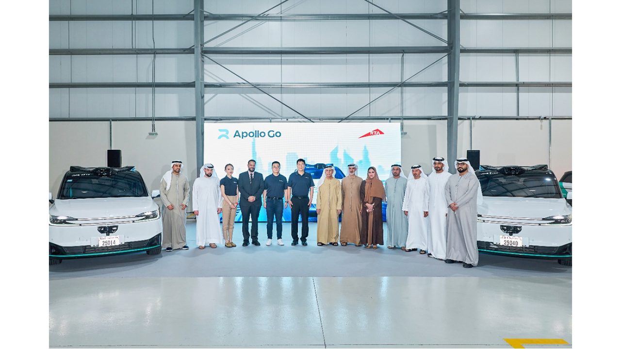 UAE officials and Apollo Go representatives posing with autonomous vehicles at a presentation event