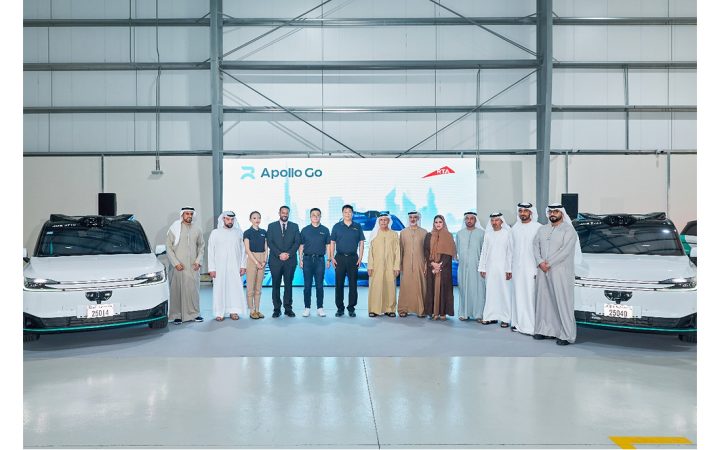 UAE officials and Apollo Go representatives posing with autonomous vehicles at a presentation event
