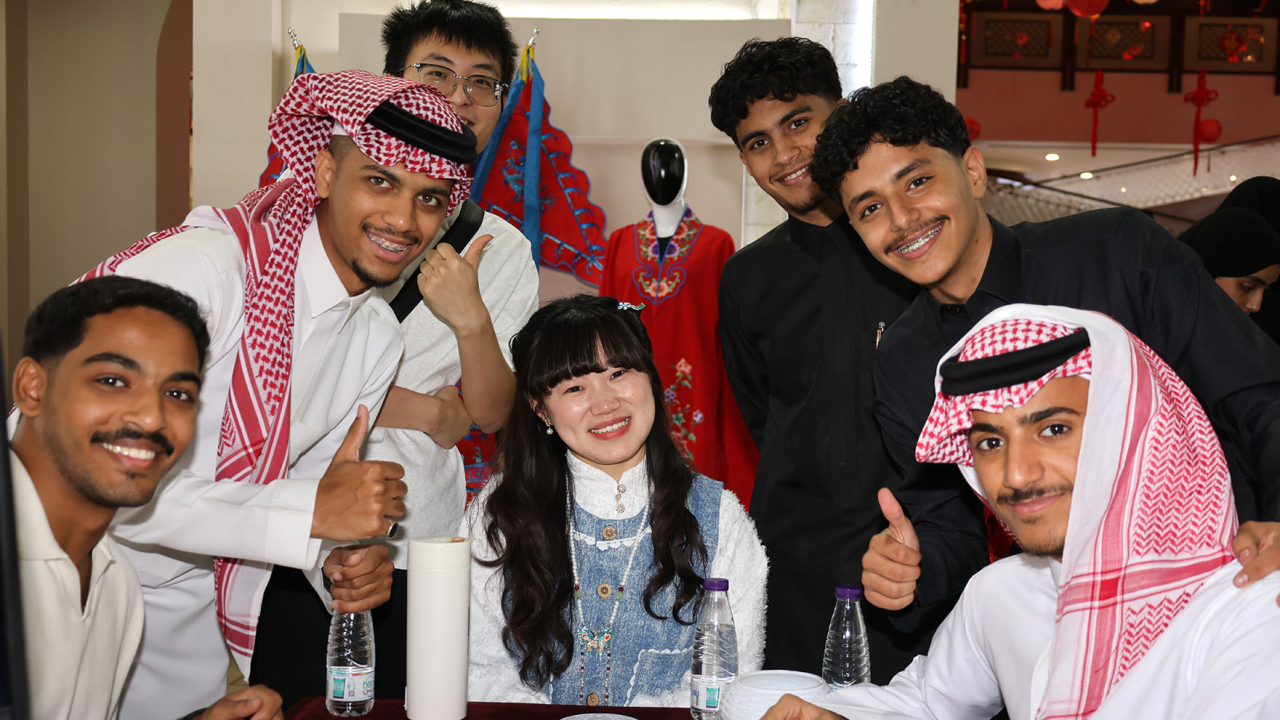 Young Emirati and Chinese participants smiling together during a cultural exchange event