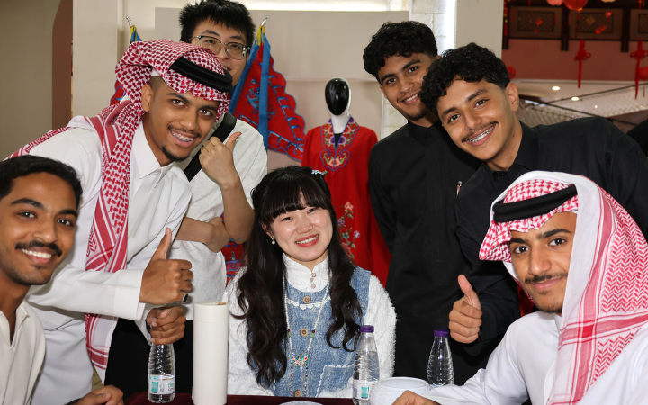 Young Emirati and Chinese participants smiling together during a cultural exchange event