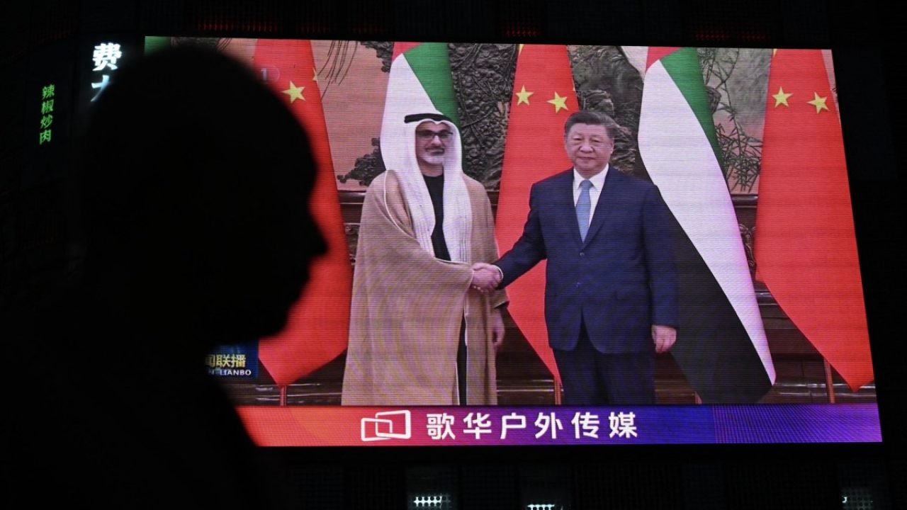 Xi Jinping and UAE Crown Prince Sheikh Khaled bin Mohamed bin Zayed shaking hands shown on a public video screen
