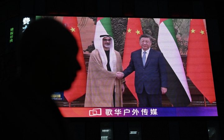 Xi Jinping and UAE Crown Prince Sheikh Khaled bin Mohamed bin Zayed shaking hands shown on a public video screen