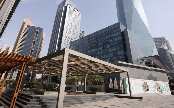 Modern office towers and shaded outdoor pedestrian terrace in a Dubai business district
