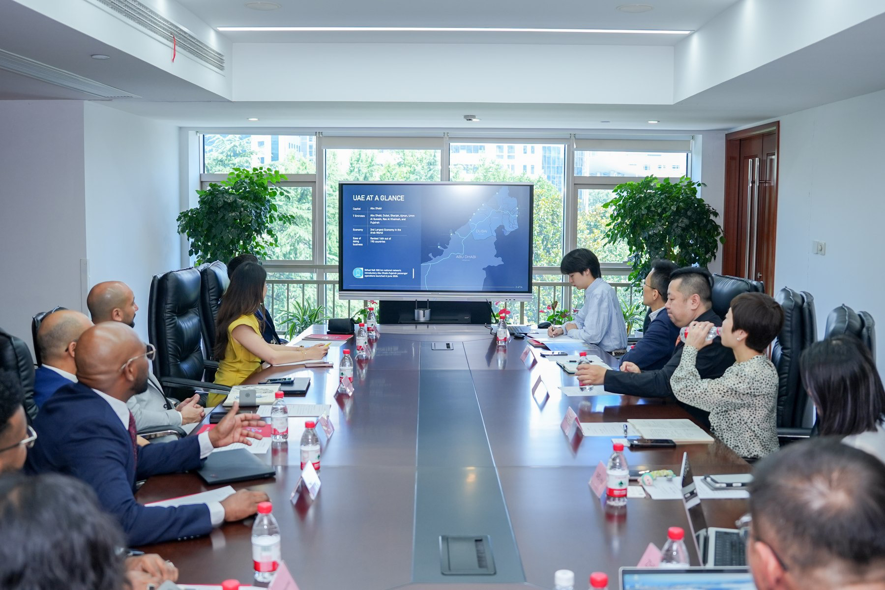 Business delegates gathered in a boardroom viewing a presentation on the UAE.