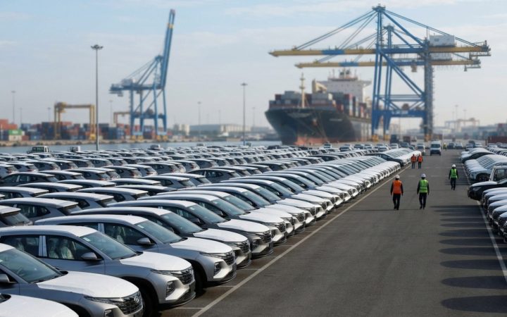 Illustration: A modern vehicle export staging ground at a commercial shipping port, showing rows of newly manufactured crossover SUVs ready for mariti