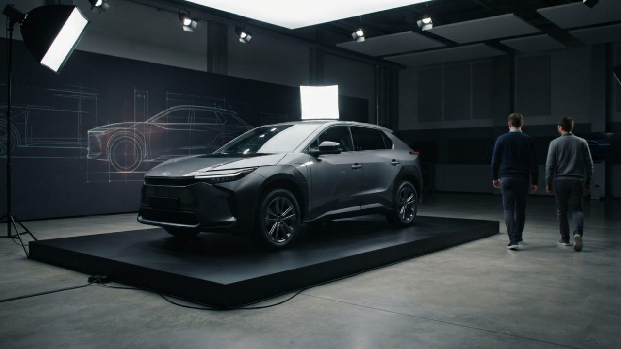 Illustration: A modern crossover vehicle on display on a sleek exhibition platform inside an industrial automotive design studio, dramatic studio ligh