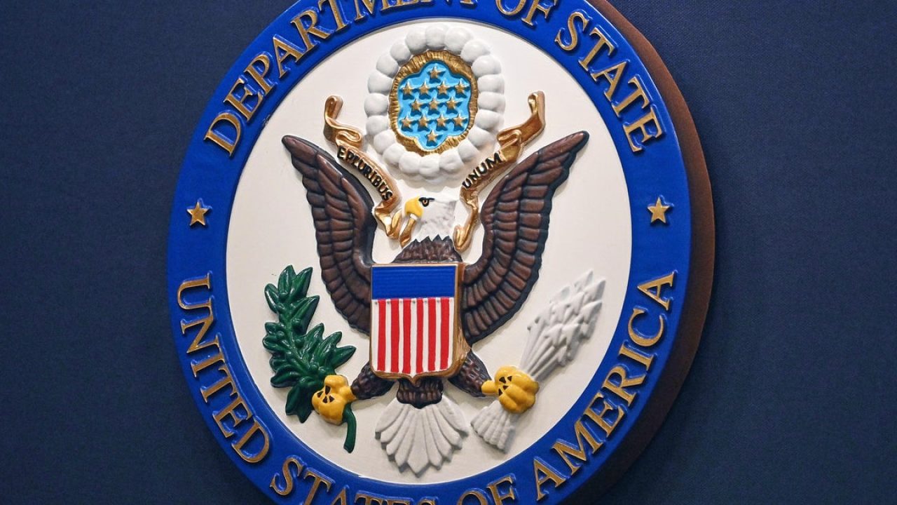 Seal of the United States Department of State mounted on a blue wall