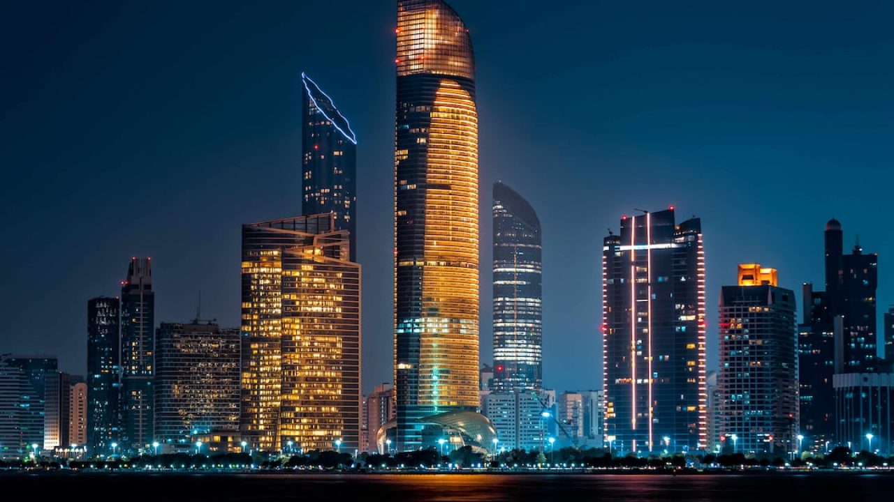 Illuminated modern skyscrapers along the waterfront skyline of Abu Dhabi at night