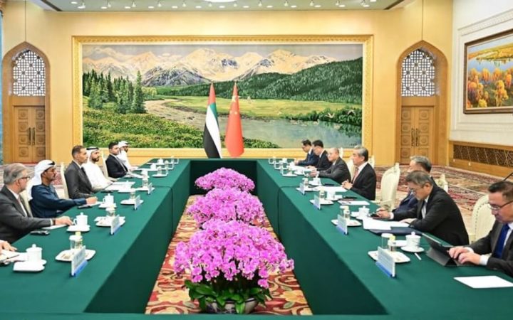 UAE and Chinese delegations seated at a formal conference table with national flags in the background