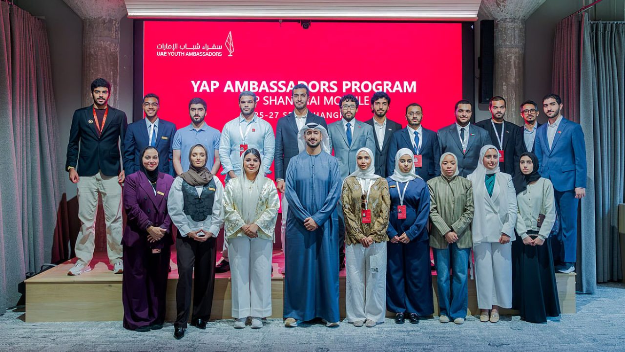Participants of the UAE Youth Ambassadors Program posing for a group photo on stage