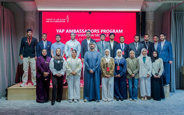 Participants of the UAE Youth Ambassadors Program posing for a group photo on stage