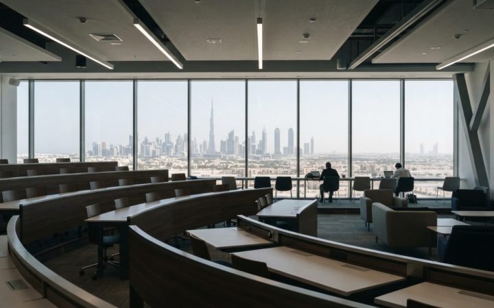 Illustration: Editorial photograph of a contemporary university lecture theatre and executive study lounge in Dubai Healthcare City, featuring floor-t